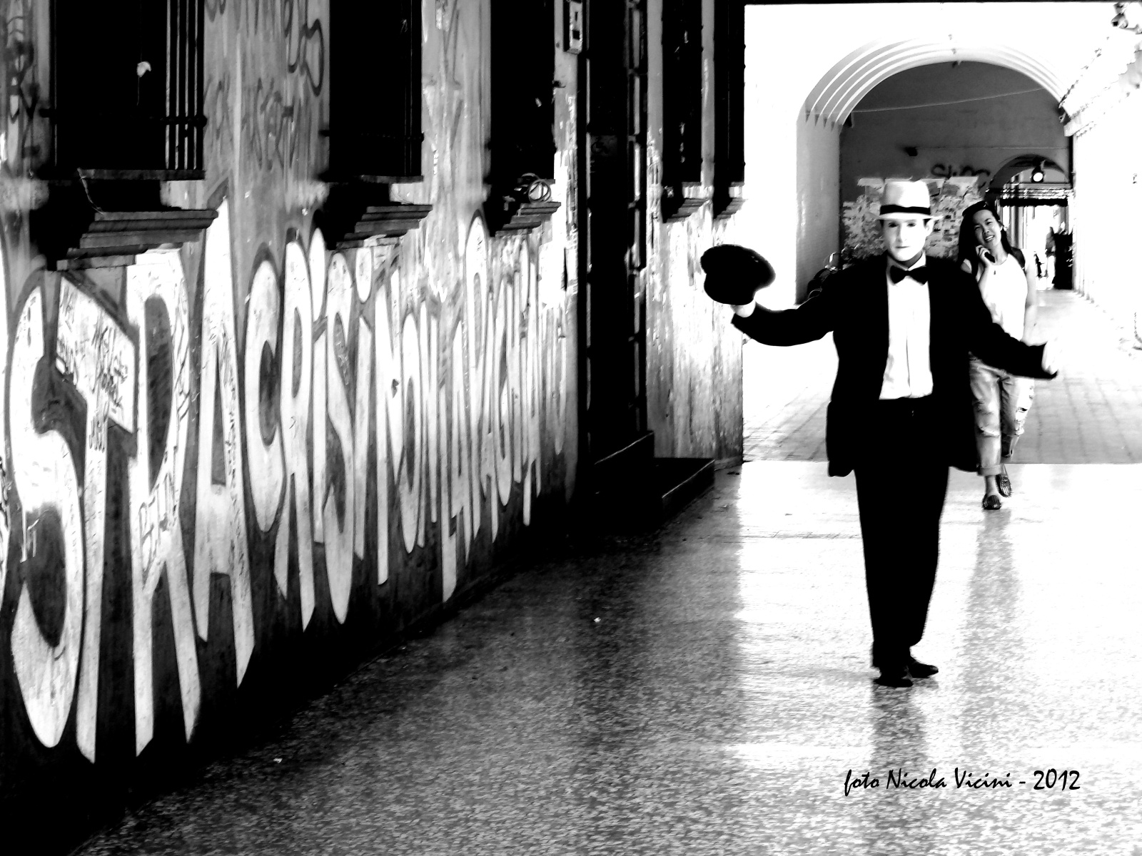 il mimo - Reportage a Bologna, 30 Maggio 2012 
Camminando sotto ai portici, cercando di raccontare in un immagine 
uno dei momenti del quotidiano di questa splendida città.
Tre soggetti, il murale, il mimo e la ragazza sorridente col telefonino 
raccontano tre storie differenti